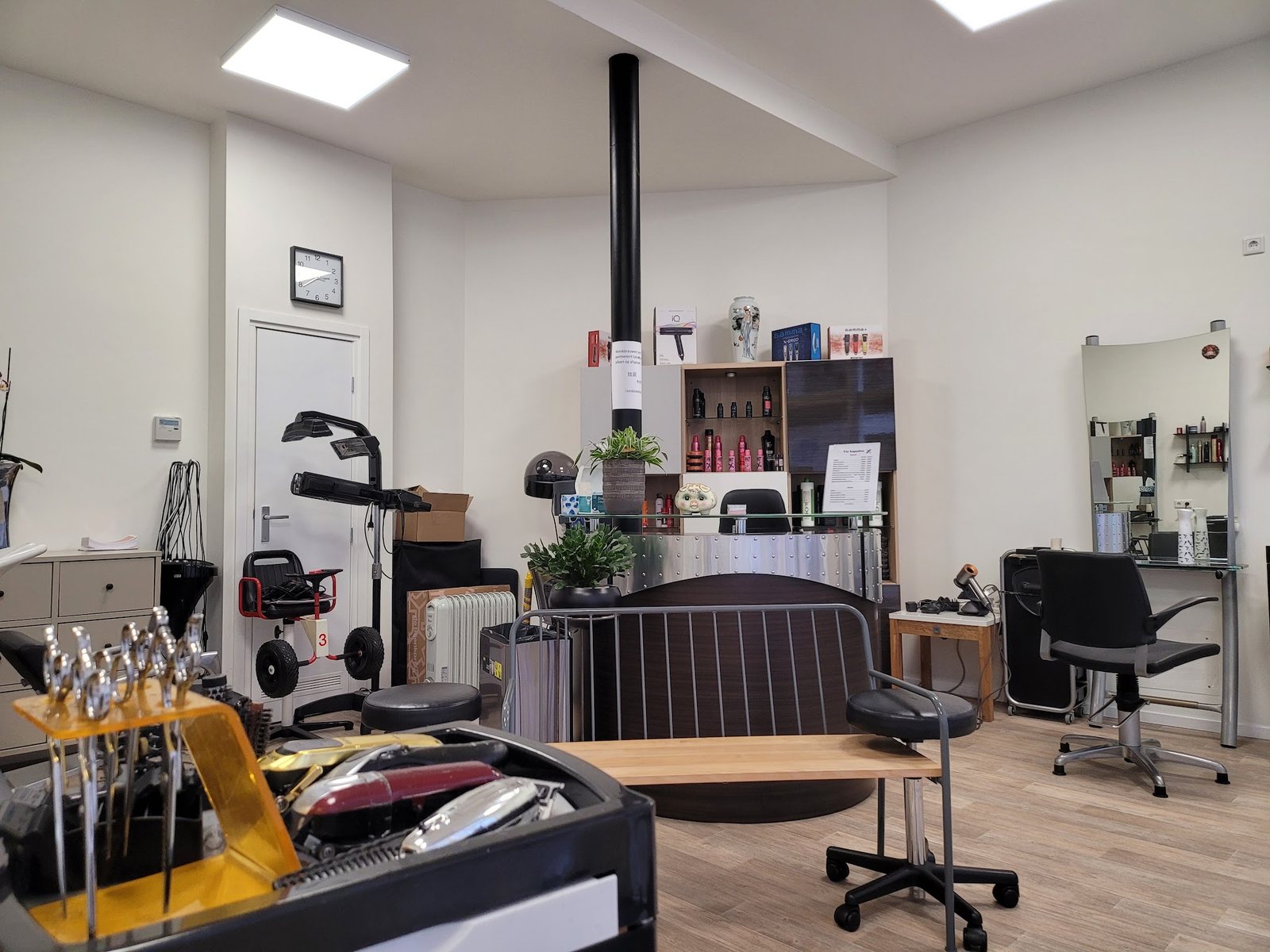De kapsalon aan de Roggenstraat: twee kapstoelen met spiegels, een houten vloer en de balie